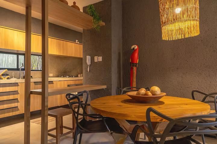 Cozinha integrada à sala de jantar com mesa redonda de madeira