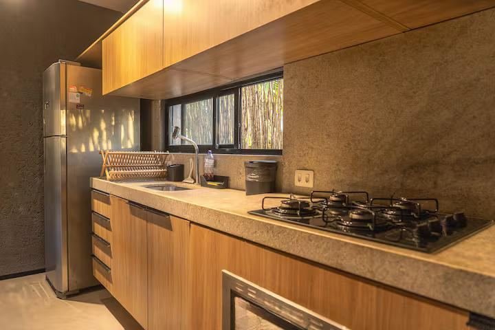 Detalhe da cozinha com fogão de cinco bocas e armários